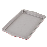 Gray non-stick baking sheet with Mickey Mouse pattern and red edges.