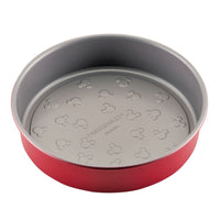 Red round baking pan with embossed design on the bottom.