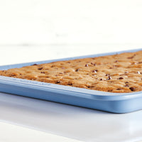 Blue pan with a fresh-baked dessert, containing chocolate chips.