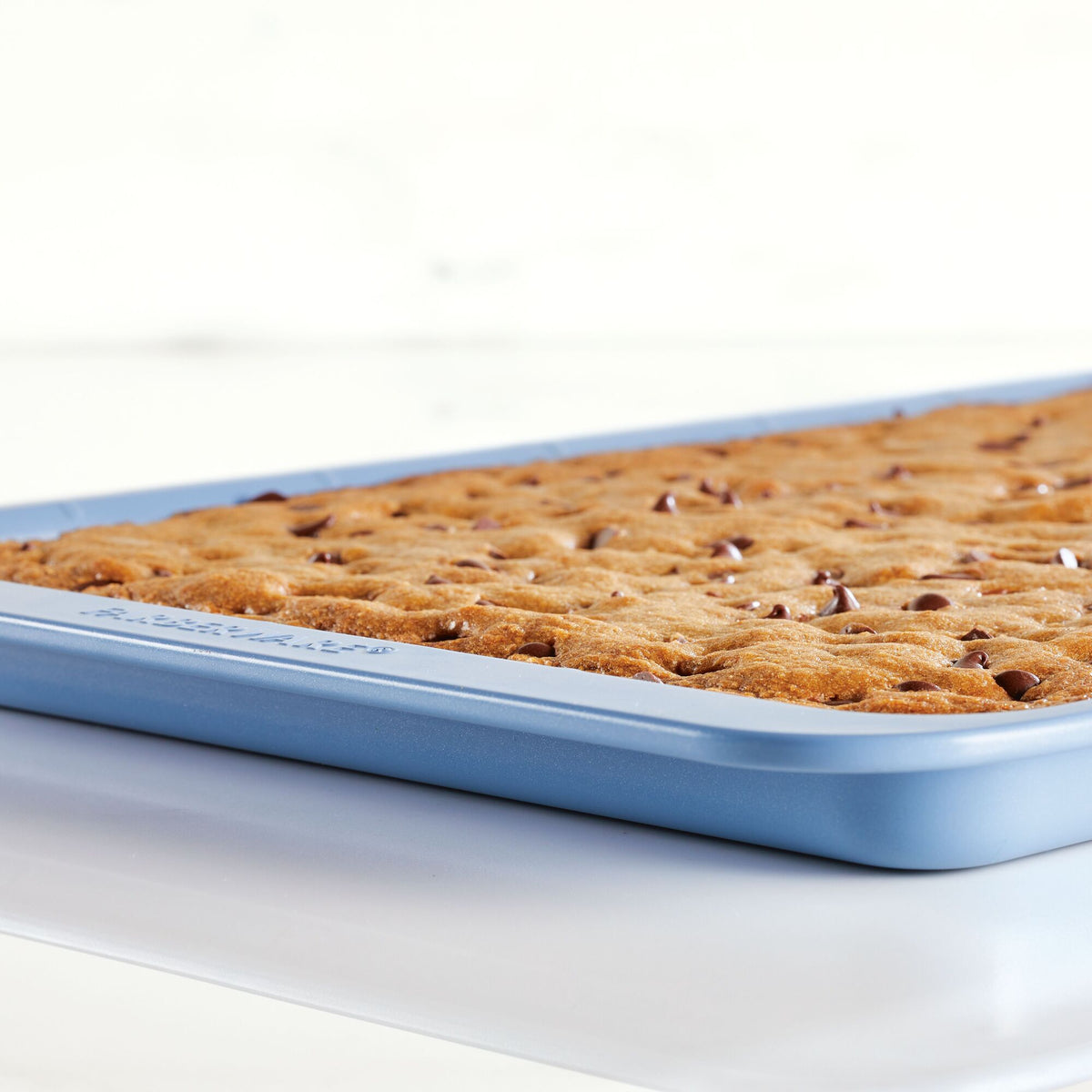 Blue pan with a fresh-baked dessert, containing chocolate chips.