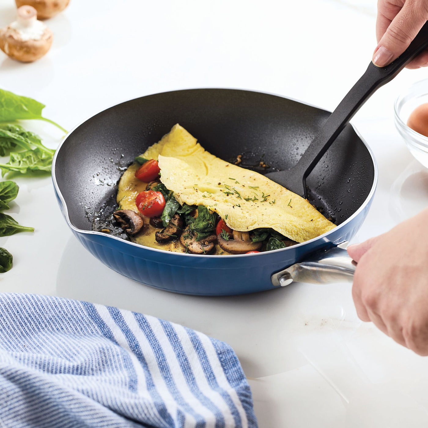 Cooking an omelette with mushrooms and spinach in a Style Nonstick Cookware Frying Pan, 10-Inch.