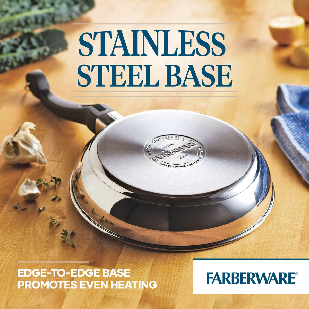 Stainless steel pan with a handle on a wooden surface near garlic and herbs.