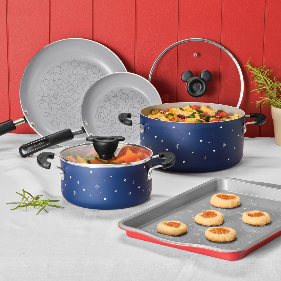 Blue cookware with playful designs on a kitchen counter with cookies.
