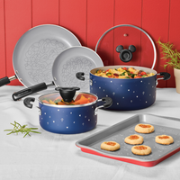 Blue cookware with playful designs on a kitchen counter with cookies.