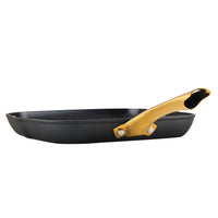 A side view of the Forged Induction Ceramic 11-Inch Square Grill Pan, featuring a black square design with a gold handle, made from forged aluminum and equipped with an induction-ready ceramic nonstick coating.