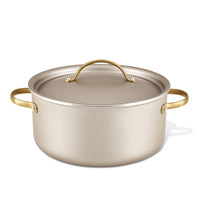 The Radiant Nonstick 5.5-Quart Dutch Oven with Lid, featuring a luxurious silver finish and gold handles, ensures excellent heat distribution, making it an essential kitchen tool.