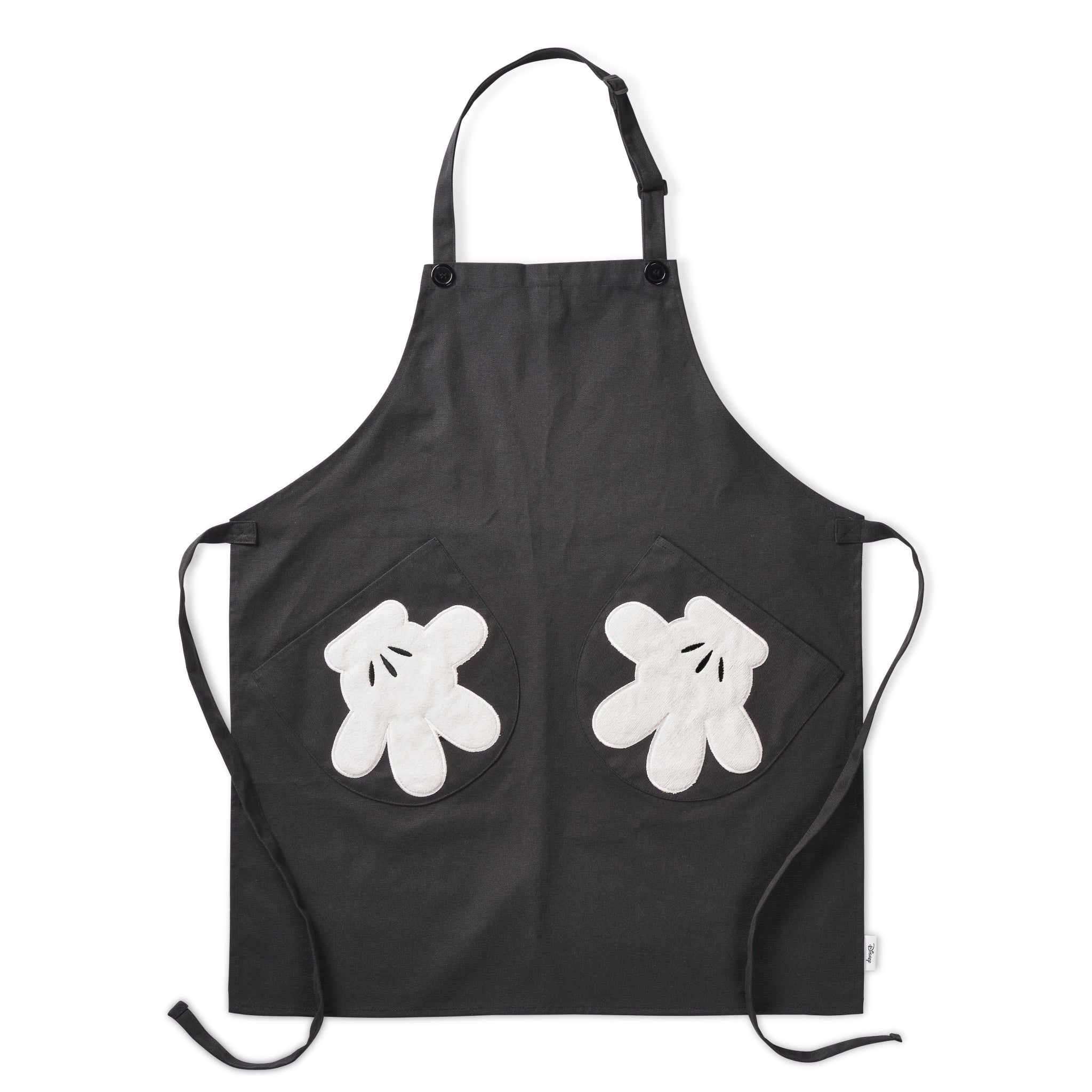 Experience the enchantment of Disney with the Apron with Glove Pockets, a black apron adorned with playful white glove pockets that capture the essence of Mickey Mouse's timeless charm.