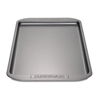 Cookie Pan with a gray metal finish and "Farberware" embossed on the edges, featuring a nonstick surface ideal for baking cookies.