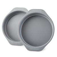 The 2-Piece Nonstick Round Cake Pan Set, featuring two gray metal pans made of heavy-gauge steel with handles, ensures even heating and can be stacked slightly offset.