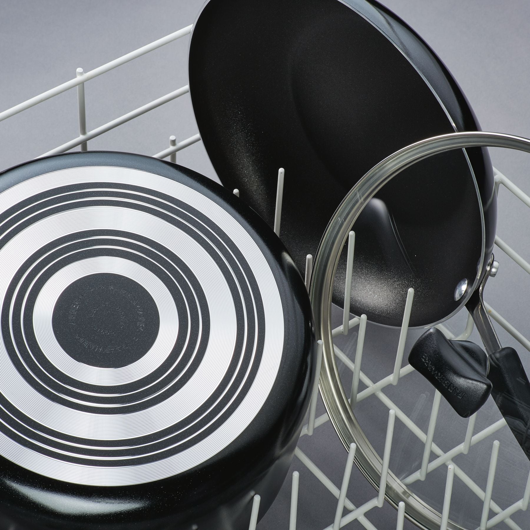 15-piece nonstick cookware set items with lids positioned upside down in a dishwasher rack.