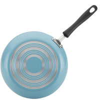 The 15-Piece Nonstick Cookware Set includes a blue frying pan with a black handle and silver concentric circles on the base, crafted from heavy gauge aluminum for durability. It features DiamondMax technology, ensuring efficient cooking and easy cleanup.
