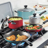 Four kitchen vessels, featuring the 10.5-Quart Nonstick Stockpot, cook a variety of foods on a stove and are ideal for family-sized servings.