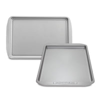 The Cookie Pan Set includes a heavy-duty rectangular and square silver baking sheet, featuring a high-performance nonstick surface for effortless cleanup, all set against a pristine white background.
