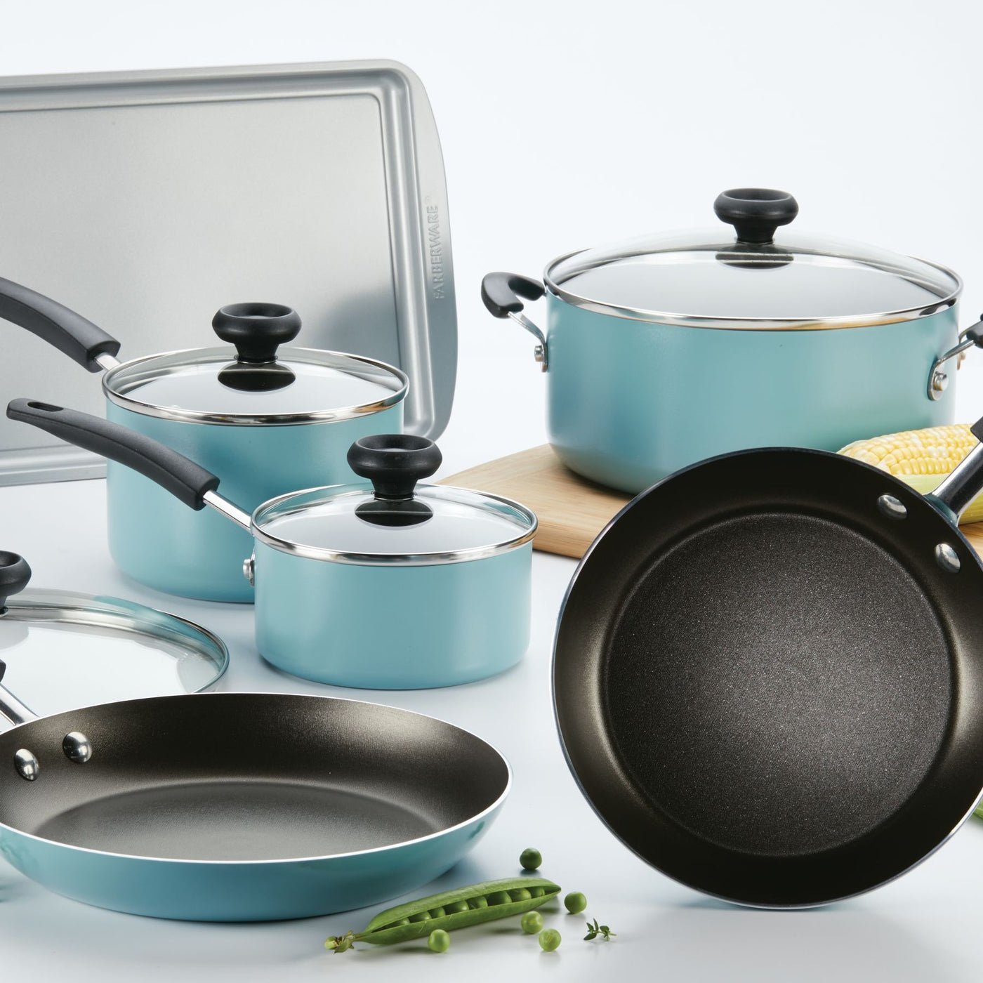 The Nonstick Frying Pan, featuring durable aluminum construction, is part of a stylish selection of blue cookware and bakeware beautifully displayed on a white surface.