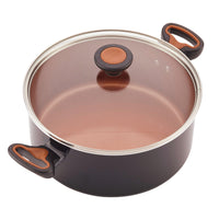 A black pot with a glass lid from the 12-Piece Copper Ceramic Nonstick Cookware Set, featuring orange-accented handles and CopperSlide technology for effortless food release.