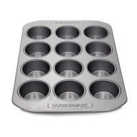 A Muffin Pan with a 12-cup capacity rests on a white background, ideal for crafting delicious chocolate chip cupcakes or blueberry muffins.